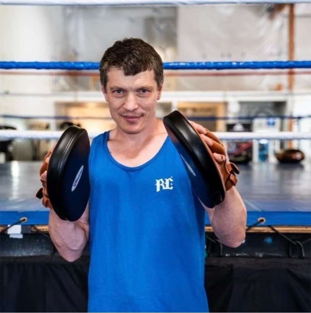 Coach holding focus mitts in the boxing ring
